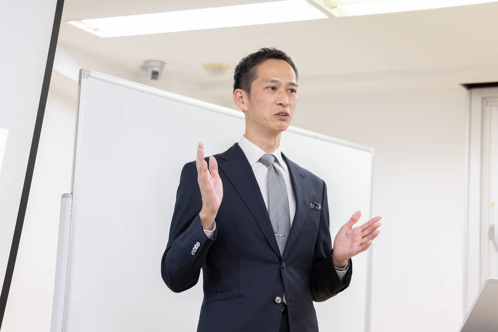 経営者向けセミナーで両手を広げて話す井口大成