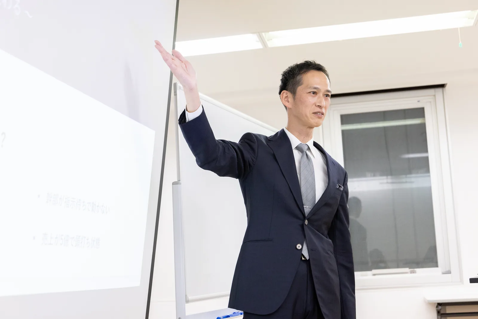 マイクを持って経営者へ語る井口大成